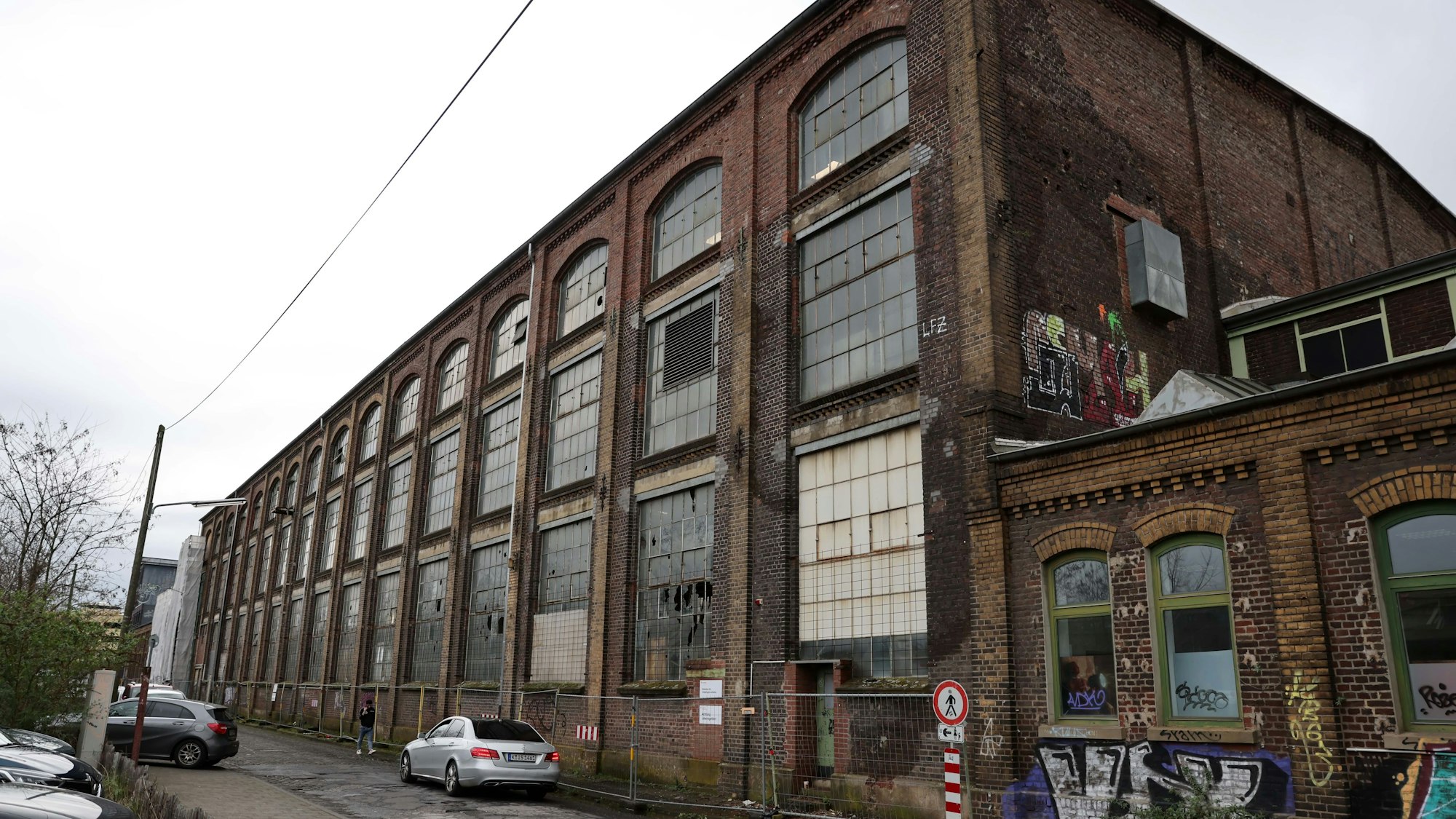 An der Halle sind Fensterscheiben kaputt geschlagen. Die Halle selbst ist mit Bauzäunen eingezäunt.