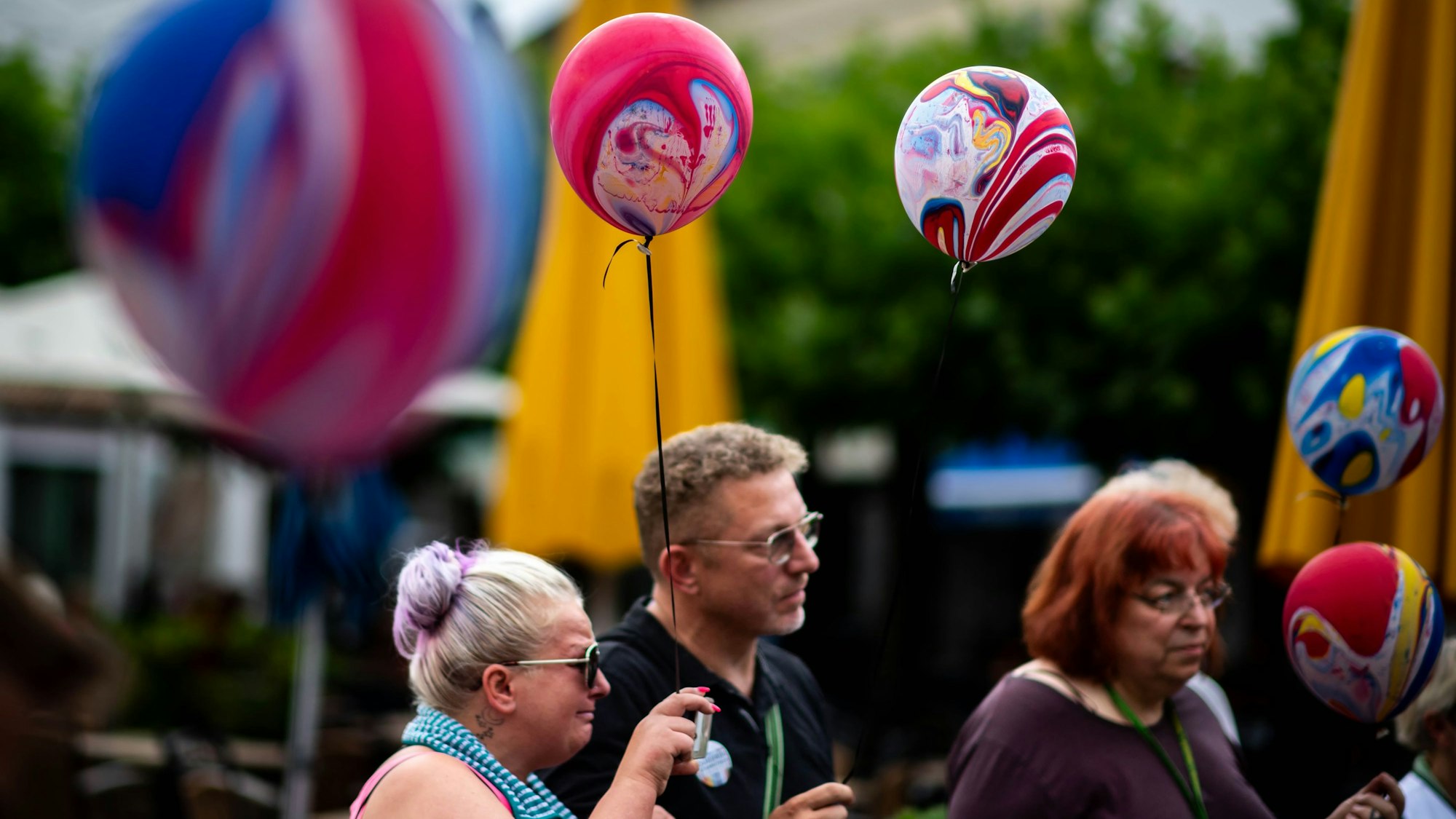 Das Bild zeigt einige Teilnehmer an der Gedenkveranstaltung auf dem Alten Markt. Sie haben alle einen bunten Luftballon in der Hand.