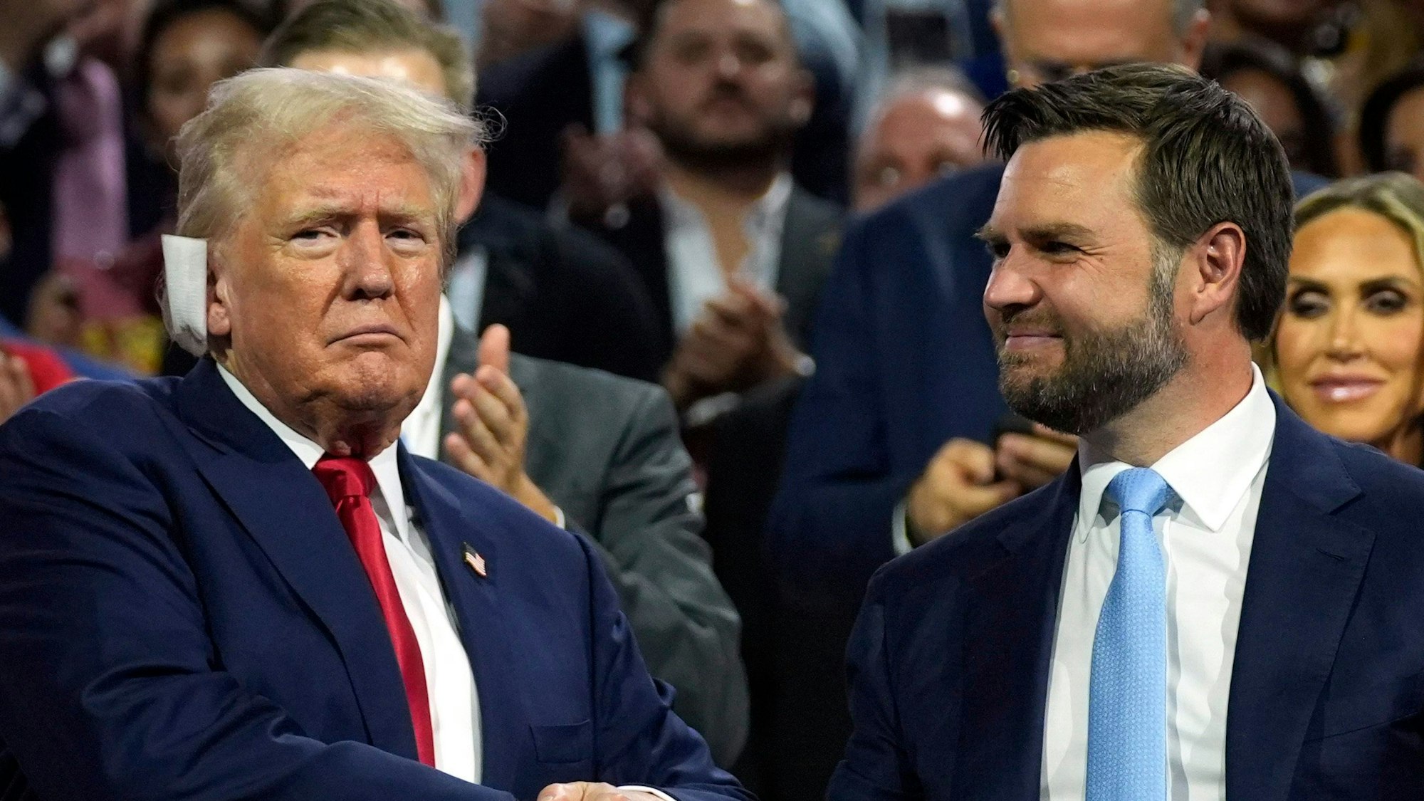 Ex-US-Präsident Donald Trump präsentiert sich bei der Republican National Convention mit seinem Vizepräsidentschaftskandidaten J.D. Vance. Am rechten Ohr trägt er nach seiner Schussverletzung ein großes Pflaster.dpa