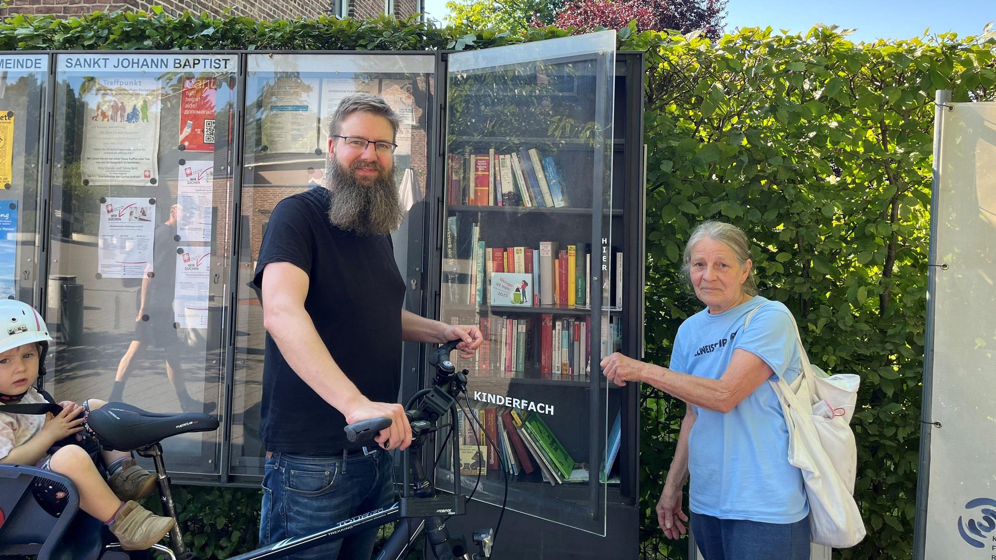 Die beiden stehen vor dem Bücherschrank.