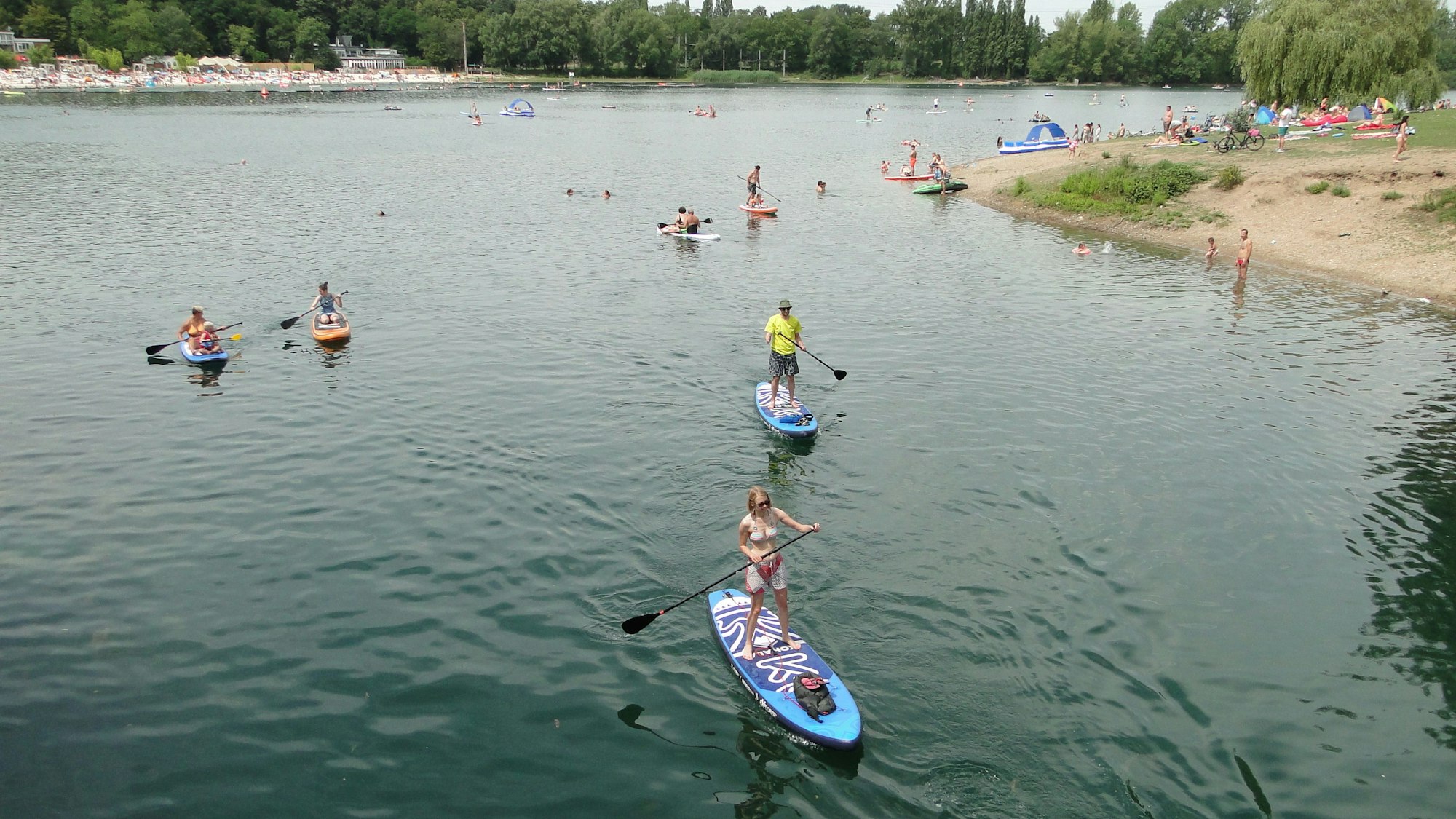 Mehrere Stand-up-Paddler paddeln über den Fühlinger See in Chorweiler.