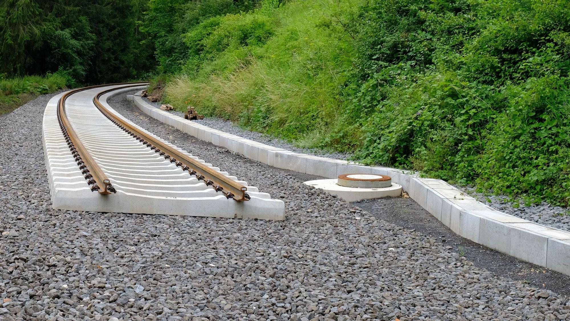Neu verlegte Bahnschwellen und Schienen enden abrupt auf dem geschotterten Bahndamm.