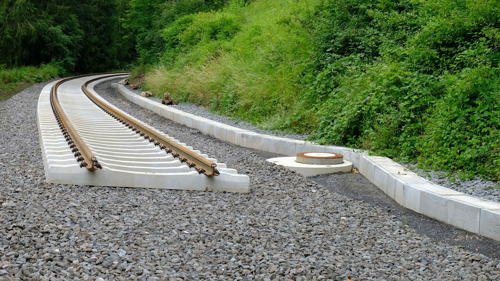 Neu verlegte Bahnschwellen und Schienen enden abrupt auf dem geschotterten Bahndamm.