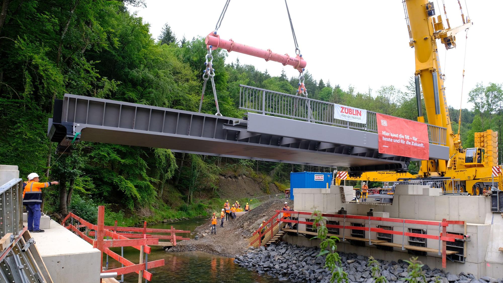 Eine vorgefertigte Dickblech-Trogbrücke wird mit einem Kran am 17. Juli 2024 bei Sötenich eingehoben.