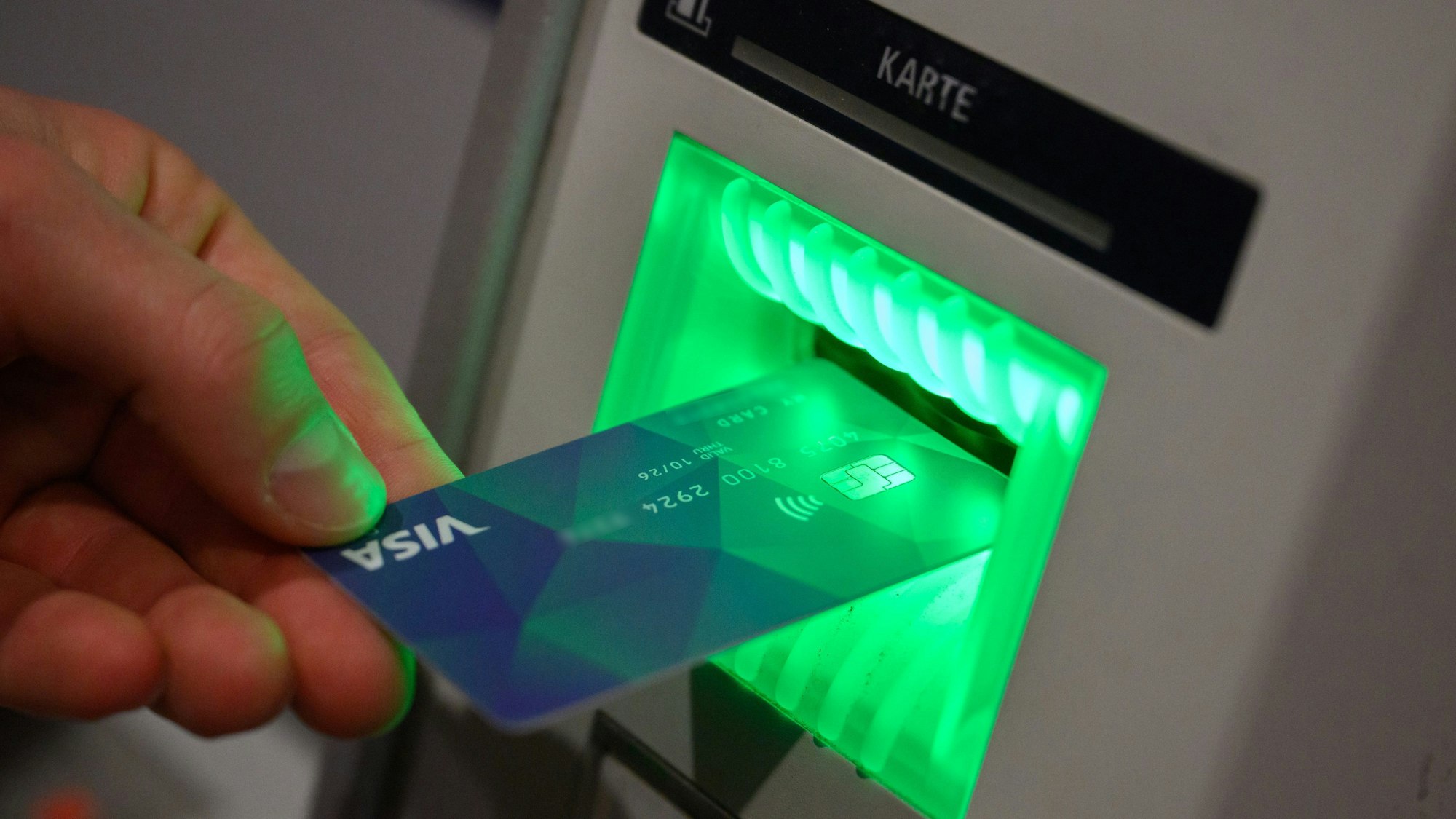 Eine Debitkarte wird in einen Geldautomaten geschoben.