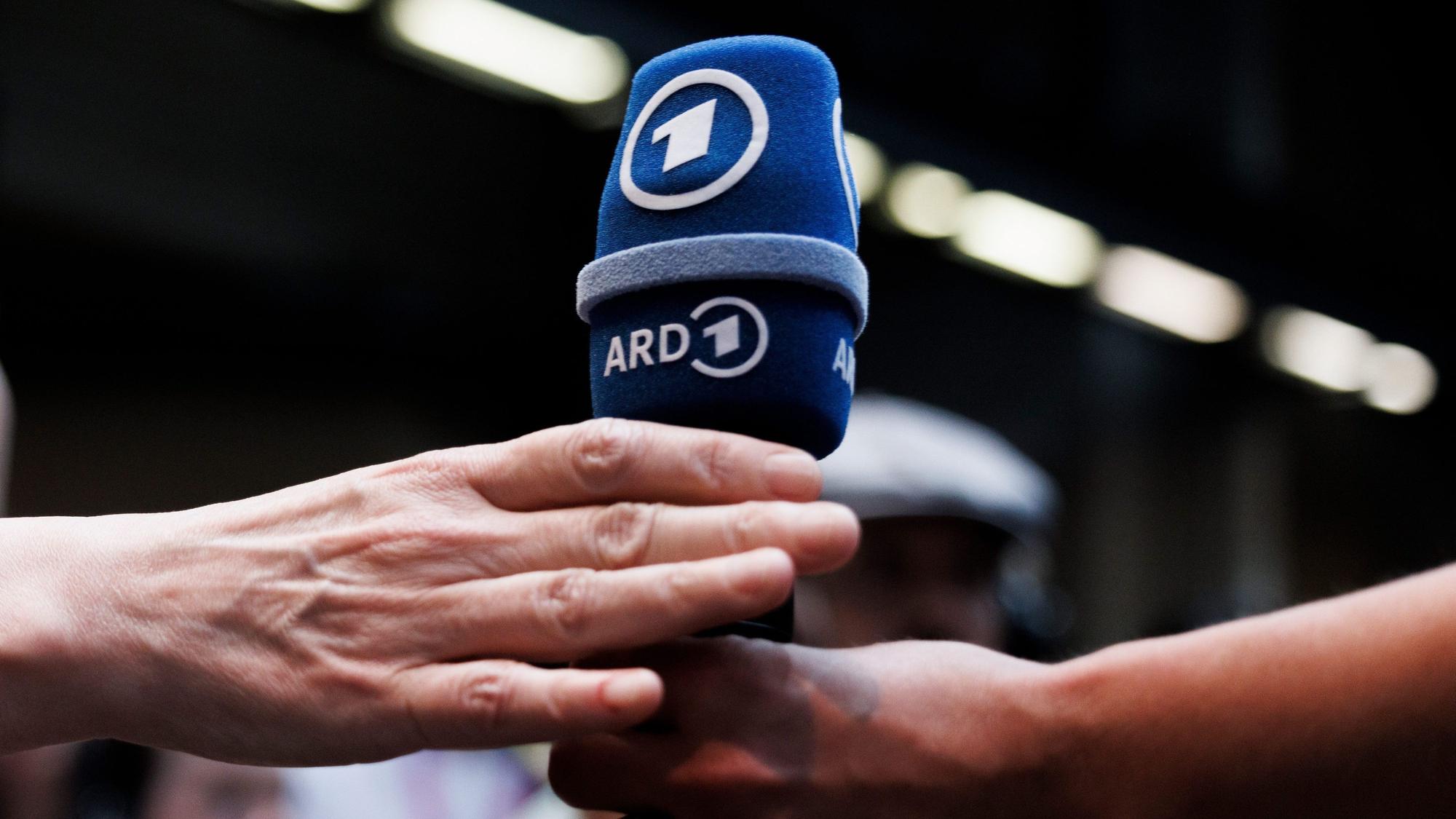 ARCHIV - 06.06.2023, Berlin: Eine Besucherin überreicht ein ARD-Mikrofon im ARD Perspective Lab während der Digital-Konferenz «Republica». (zu dpa: ««Tagesschau» von ARD-Mitarbeiter-Warnstreik betroffen») Foto: Carsten Koall/dpa +++ dpa-Bildfunk +++