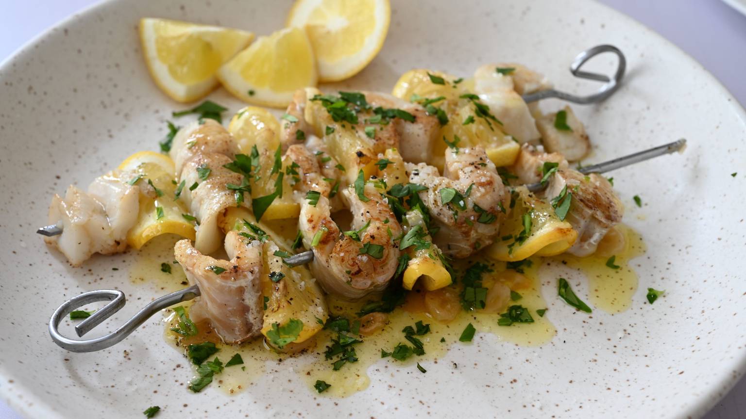 Fischstückchen und gefaltete Zitronenscheibchen sind abwechselnd aufgespießt.