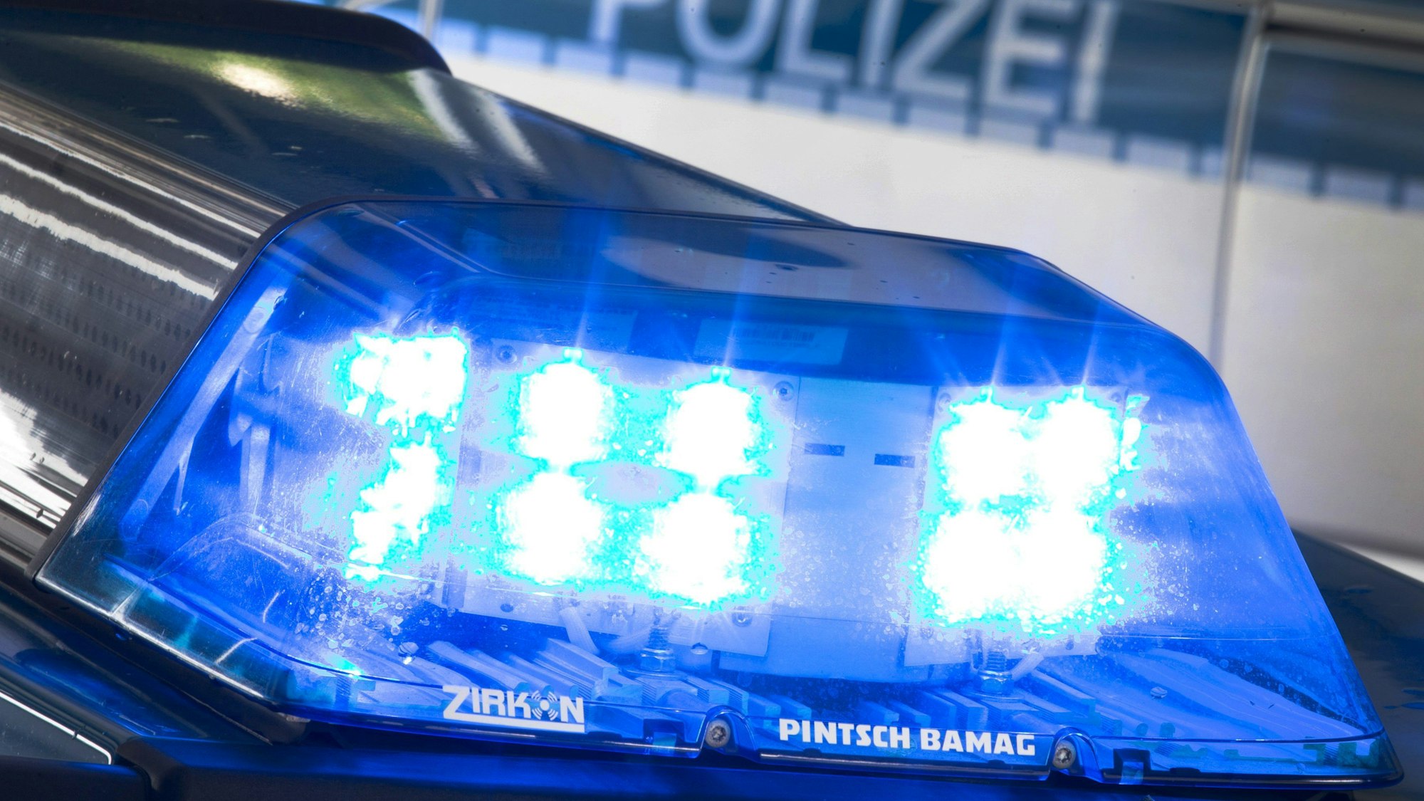Ein Blaulicht leuchtet auf dem Dach eines Polizeiwagens.