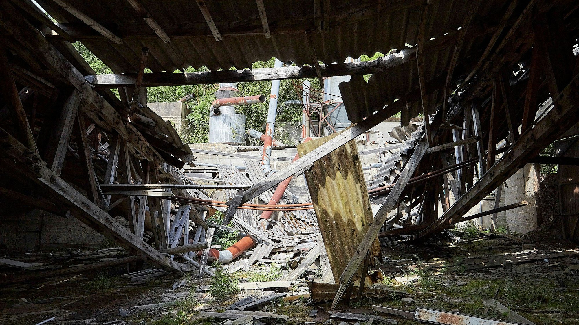 Eine Industrieruine ist die ehemalige Firma Ruhr KG bei Nettersheim. Das Bild zeigt den Blick in eine Werkshalle, deren Dach teilweise eingestürzt ist.