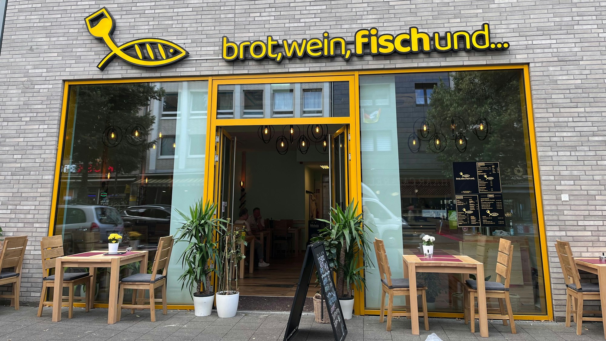 Außensicht auf ein Geschäft mit der Überschrift „brot, wein, fisch und...“.