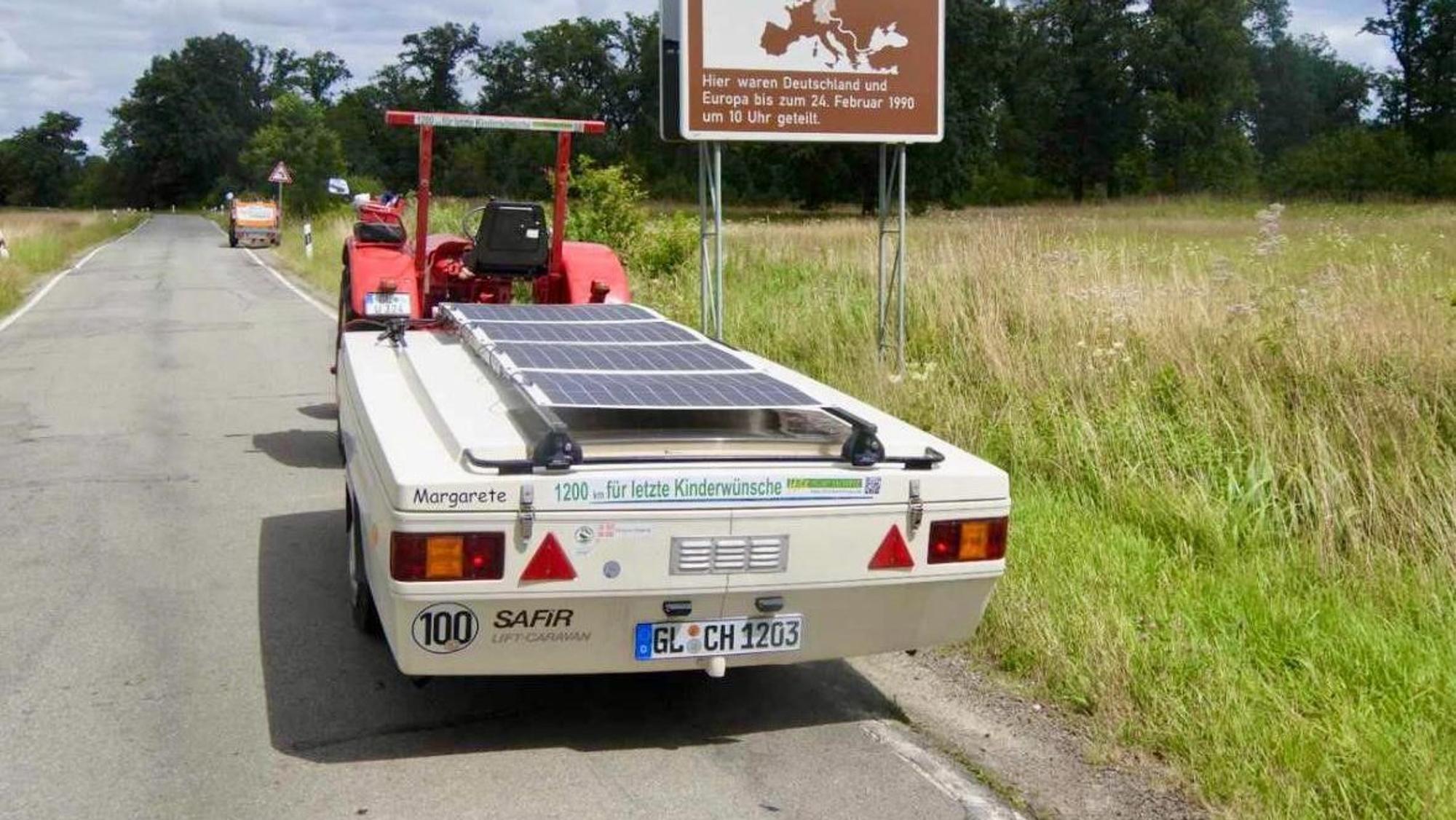 Ein Trajtor zieht einen Klapp-Caravan.