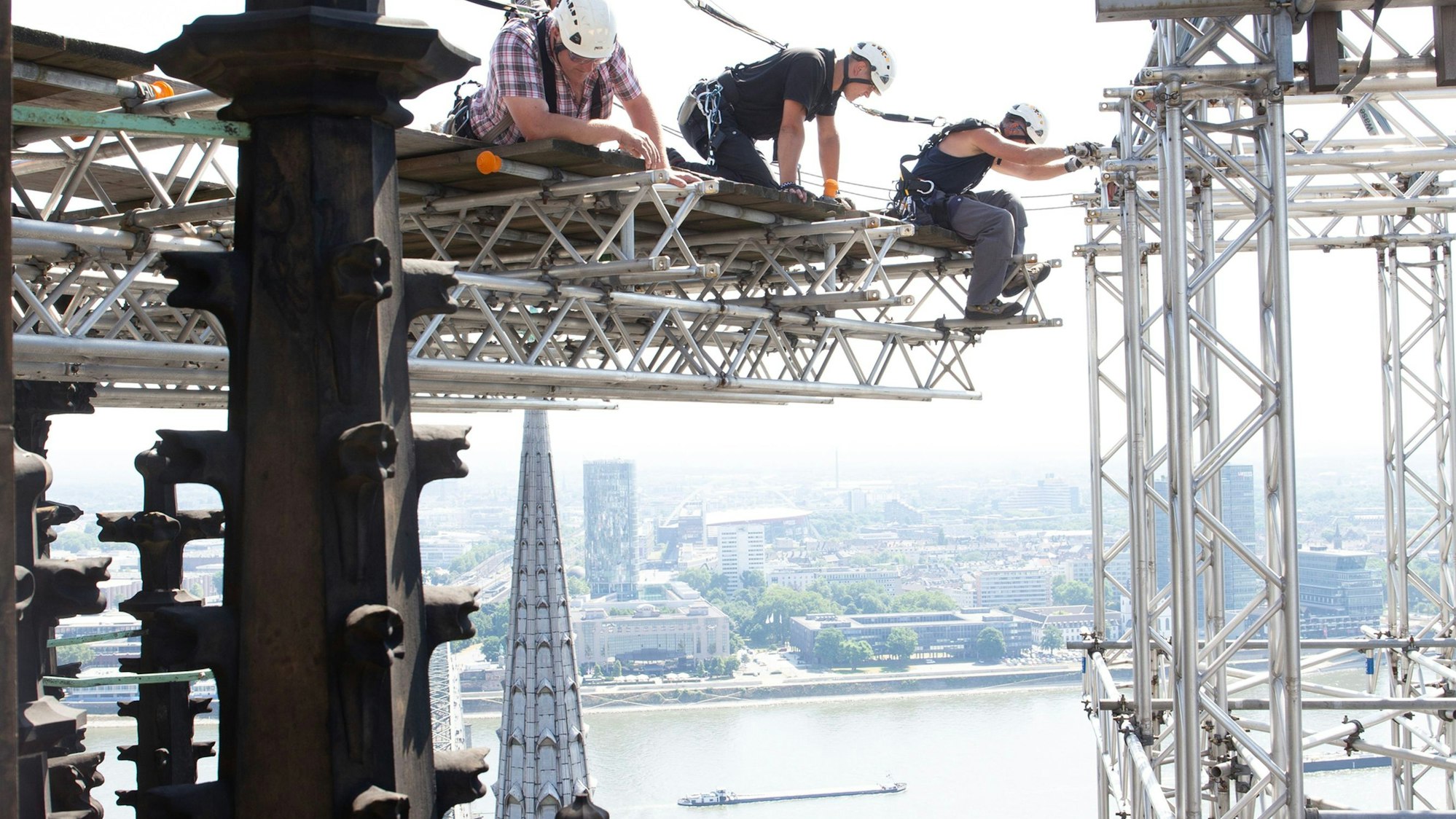Bauarbeiter nehmen das alte Hängegerüst am Nordturm ab.