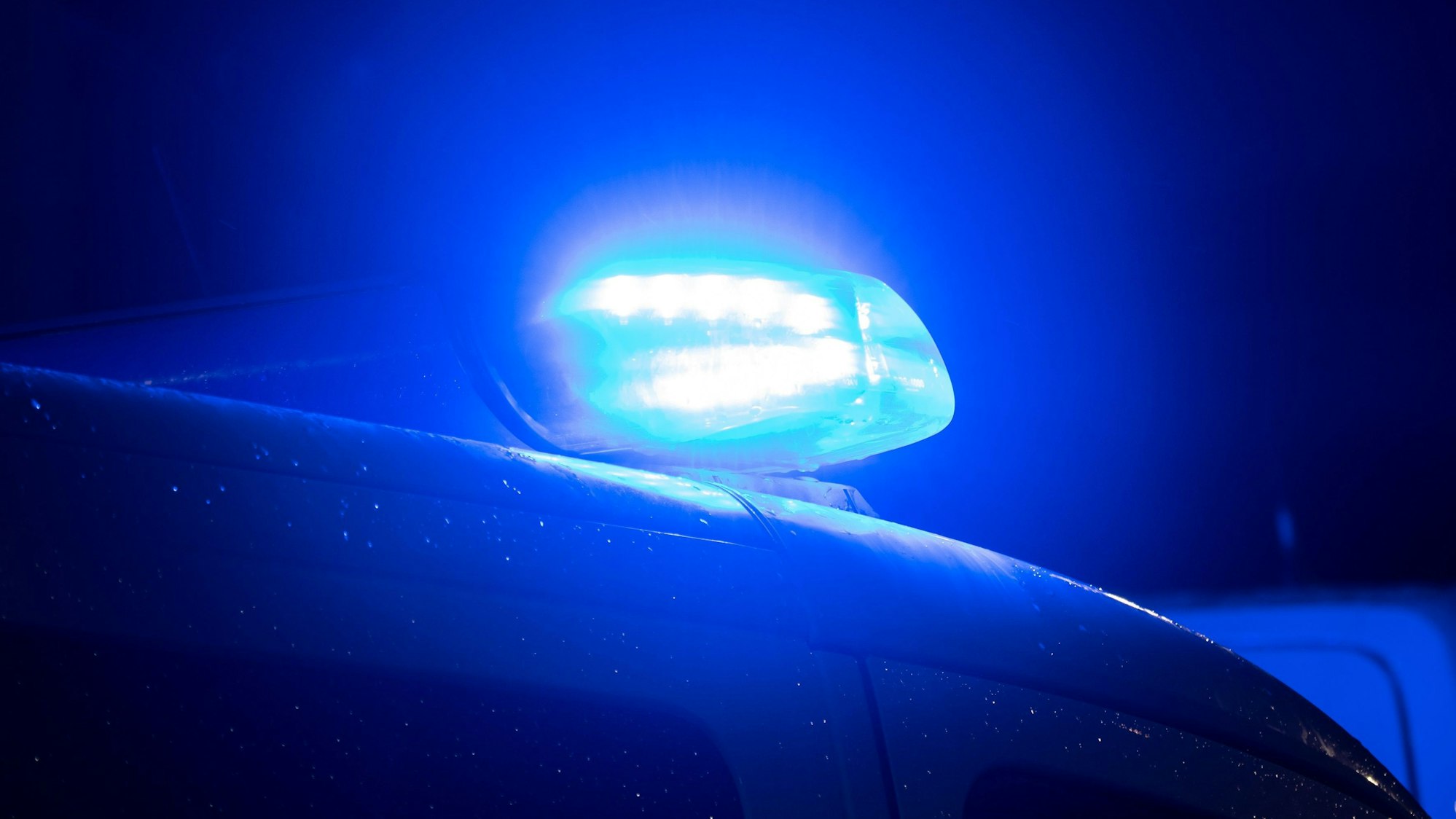 Ein Blaulicht leuchtet auf dem Dach eines Polizeiwagens.