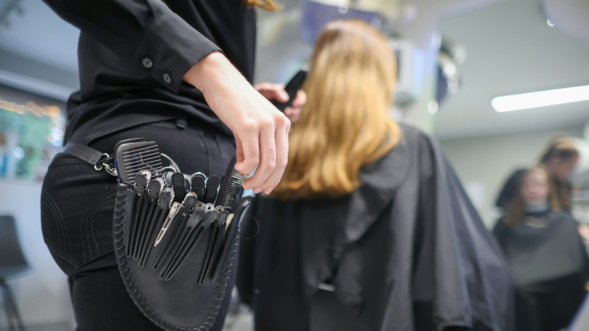 ARCHIV - 08.12.2022, Sachsen-Anhalt, Wettin-Löbejün: Eine Friseurmeisterin schneidet in einem Salon einer Kundin die Haare. (zu dpa: «Engpässe bei 21 Berufsgruppen in Thüringen») Foto: Jan Woitas/dpa +++ dpa-Bildfunk +++