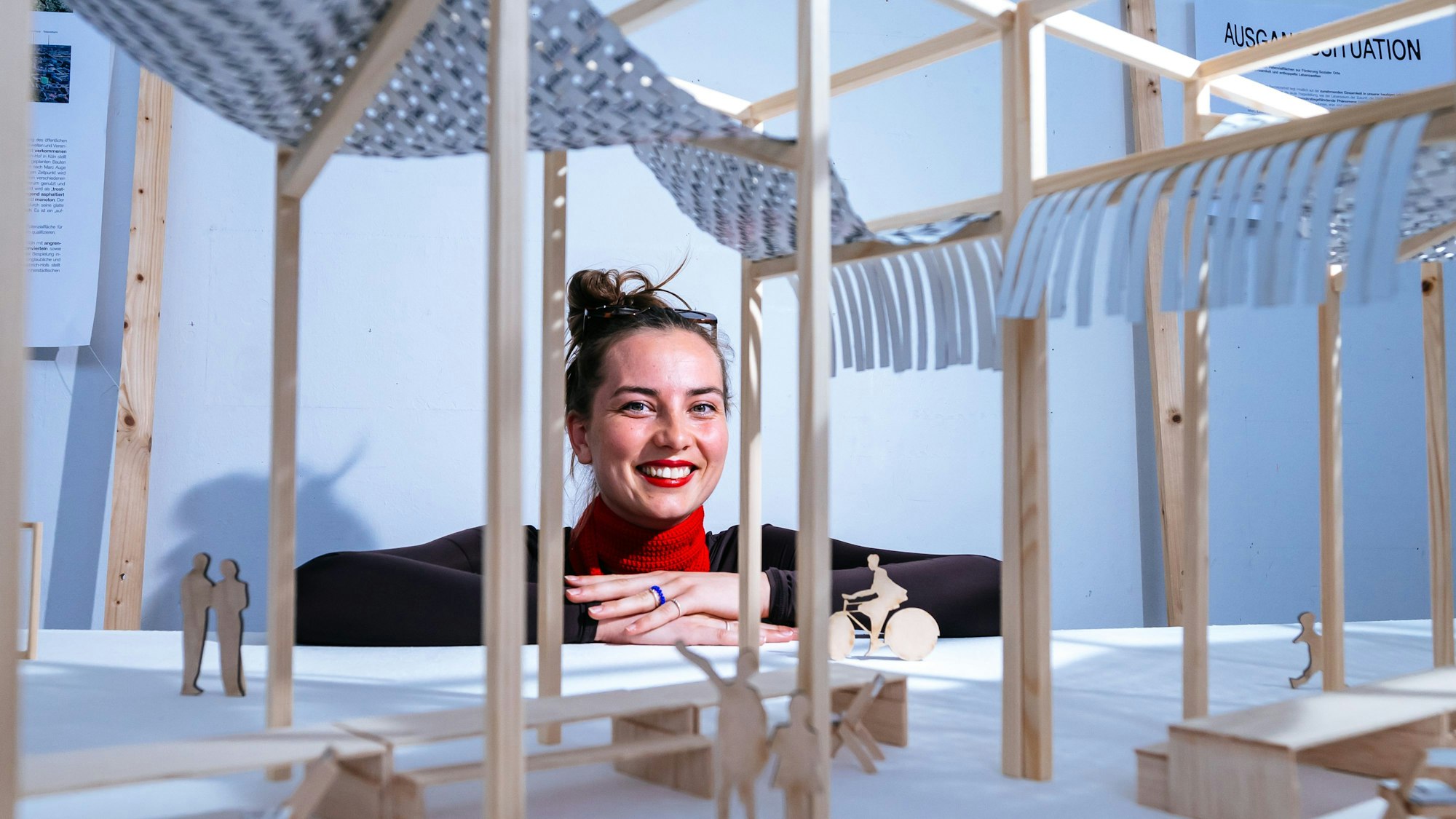 Eine junge Frau hinter einem Holz-Modell für die Möblierung eines öffentlichen Platzes.