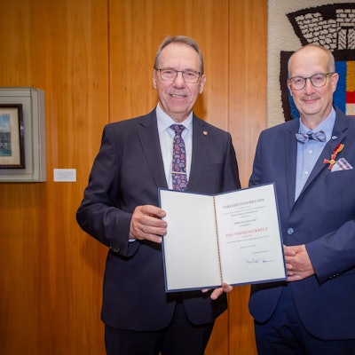 Landrat Jochen Hagt überreicht Joachim Tump die Urkunde.