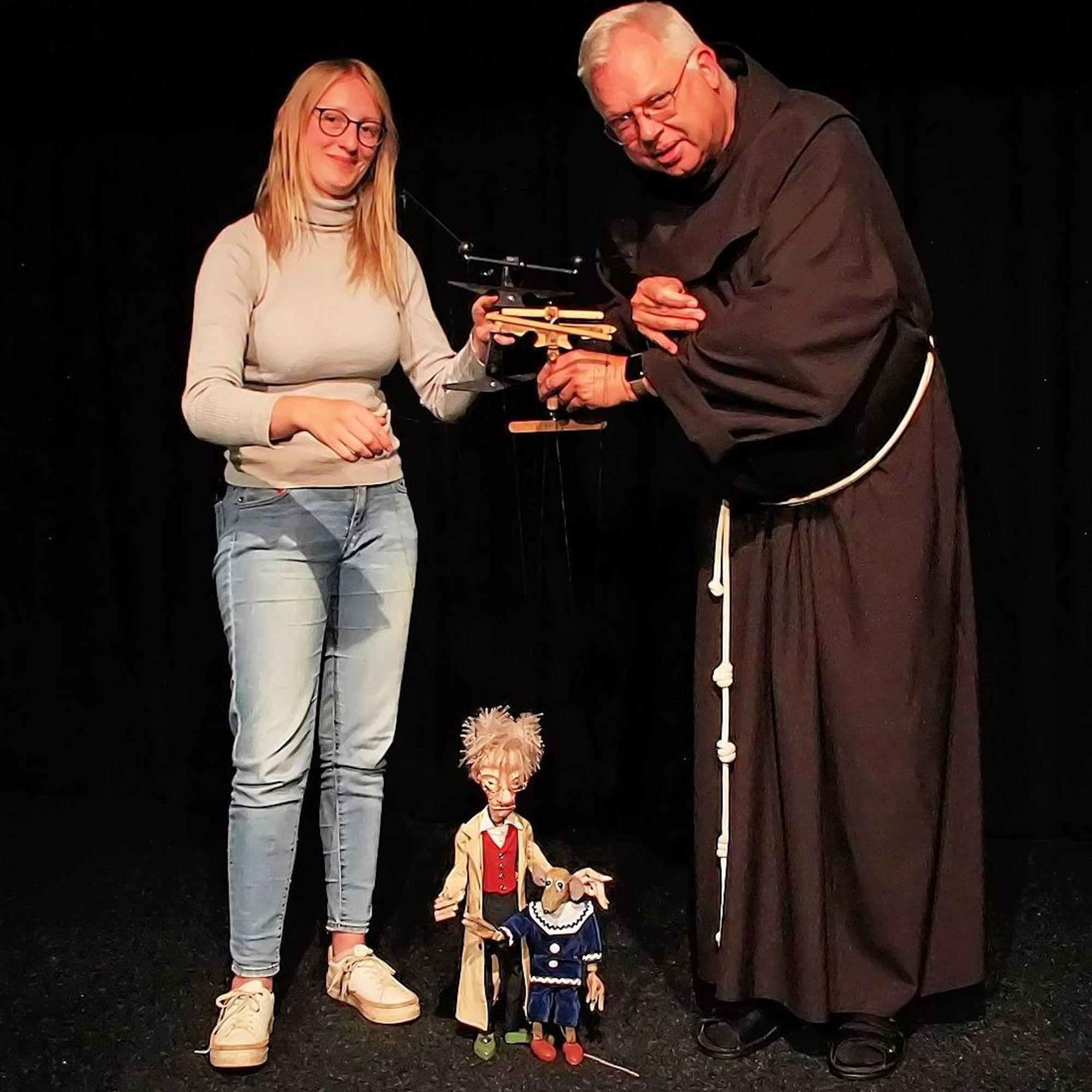 Maja Blümer und Bruder Wolfgang Mauritz stehen mit zwei Marionettenfiguren auf der Bühne ihres Theaters.
