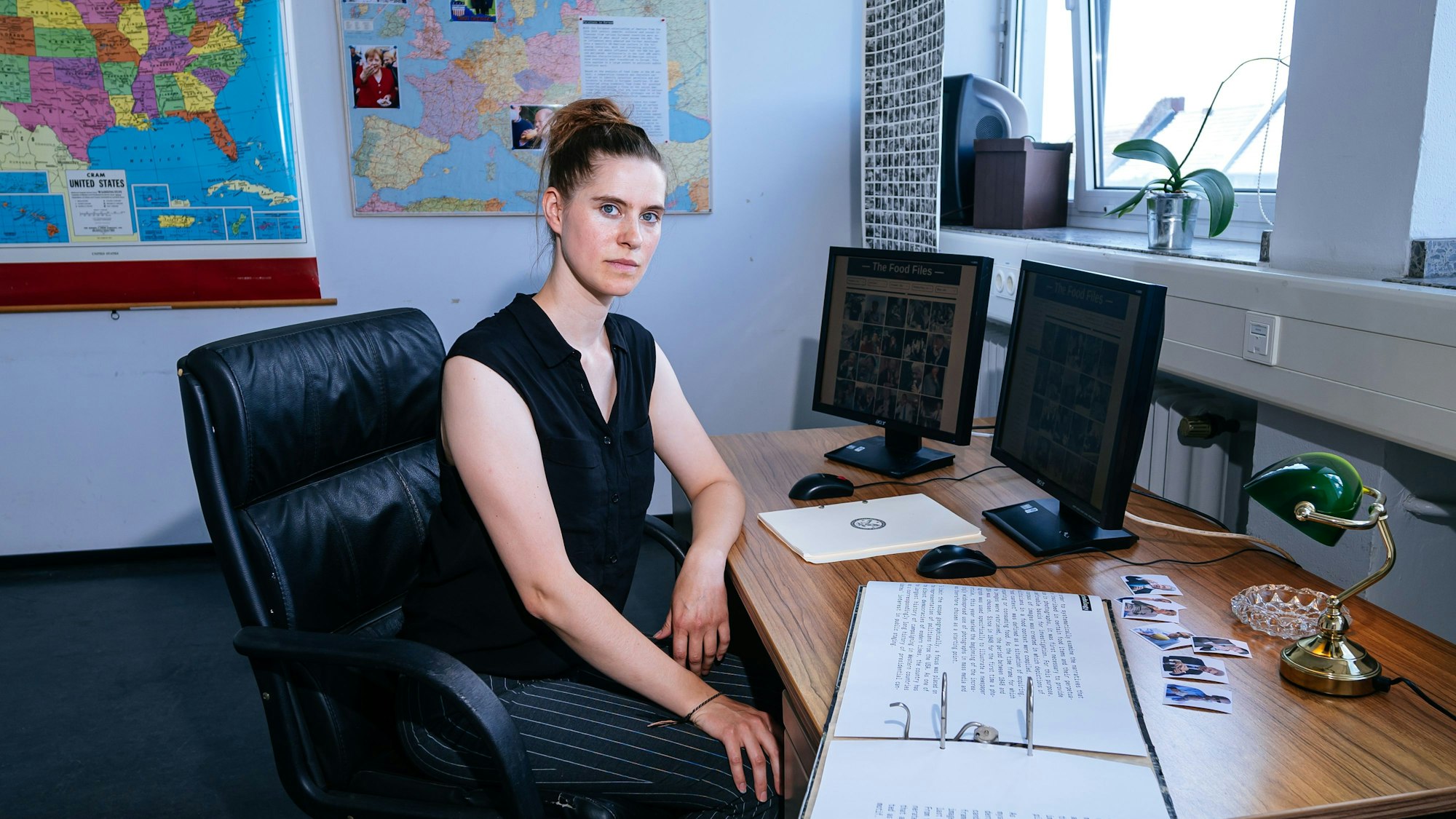 Eine Frau am Schreibtisch, darauf zwei Montitore.