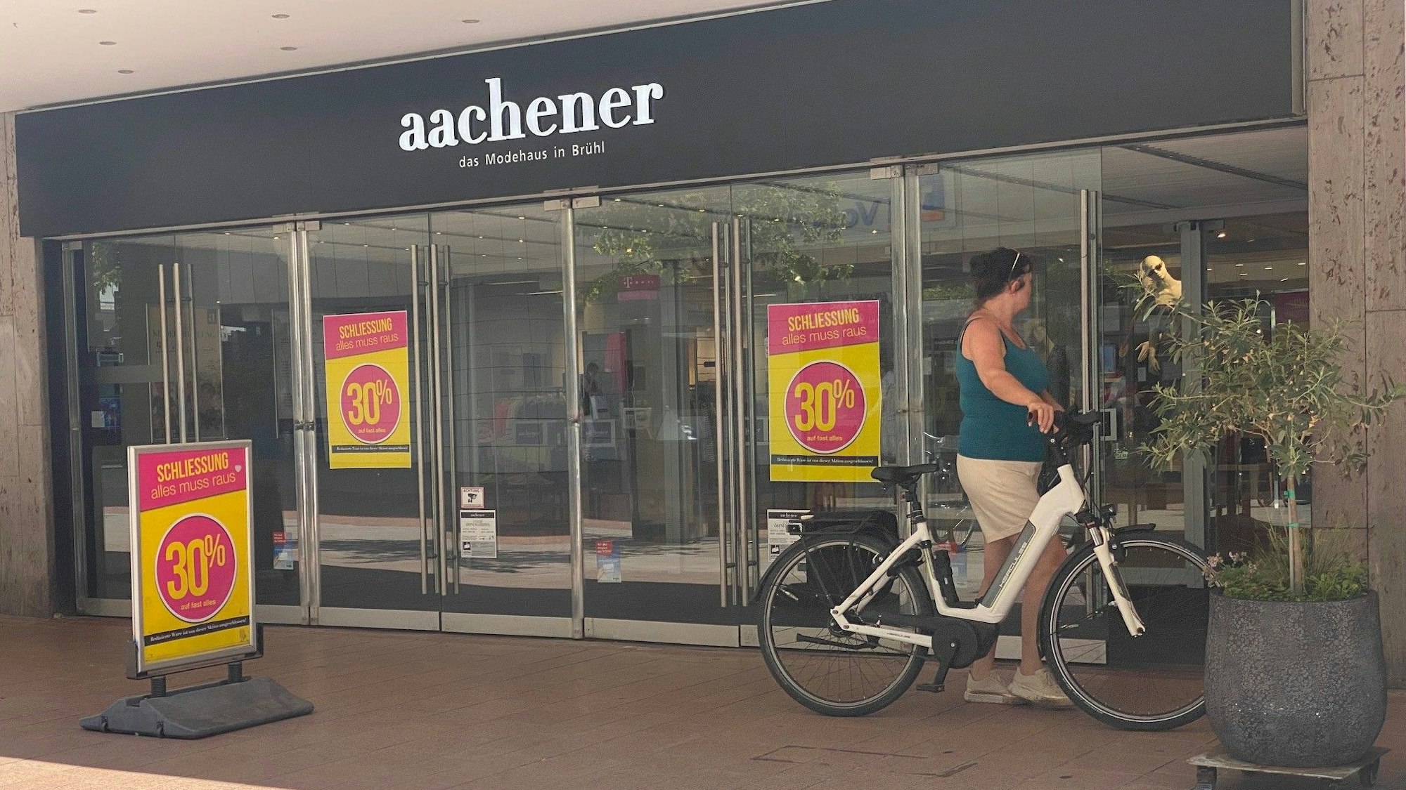 Zu sehen ist der Eingang des Modehauses Aachener in Brühl.