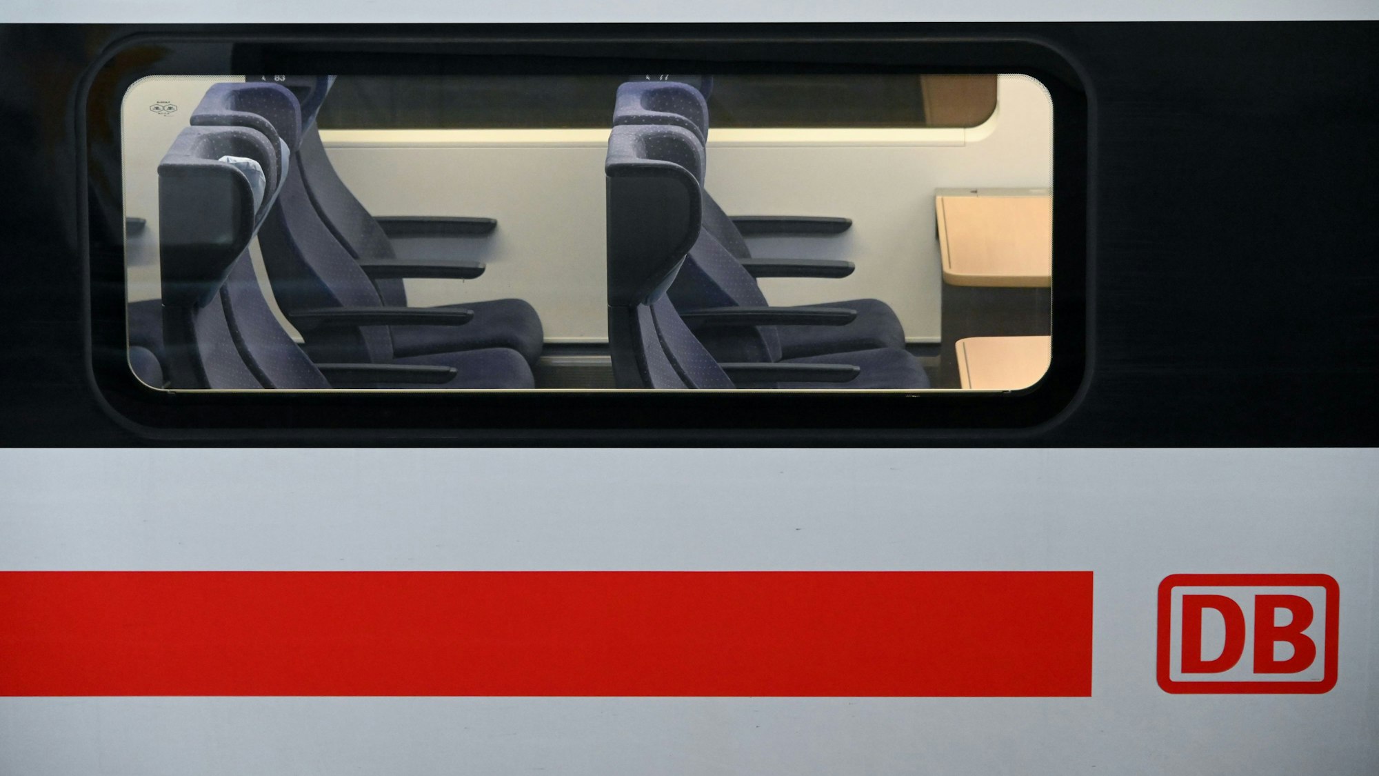 Blick auf leere 2.-Klasse-Sitzplätze in einem am Bahnhof stehenden ICE