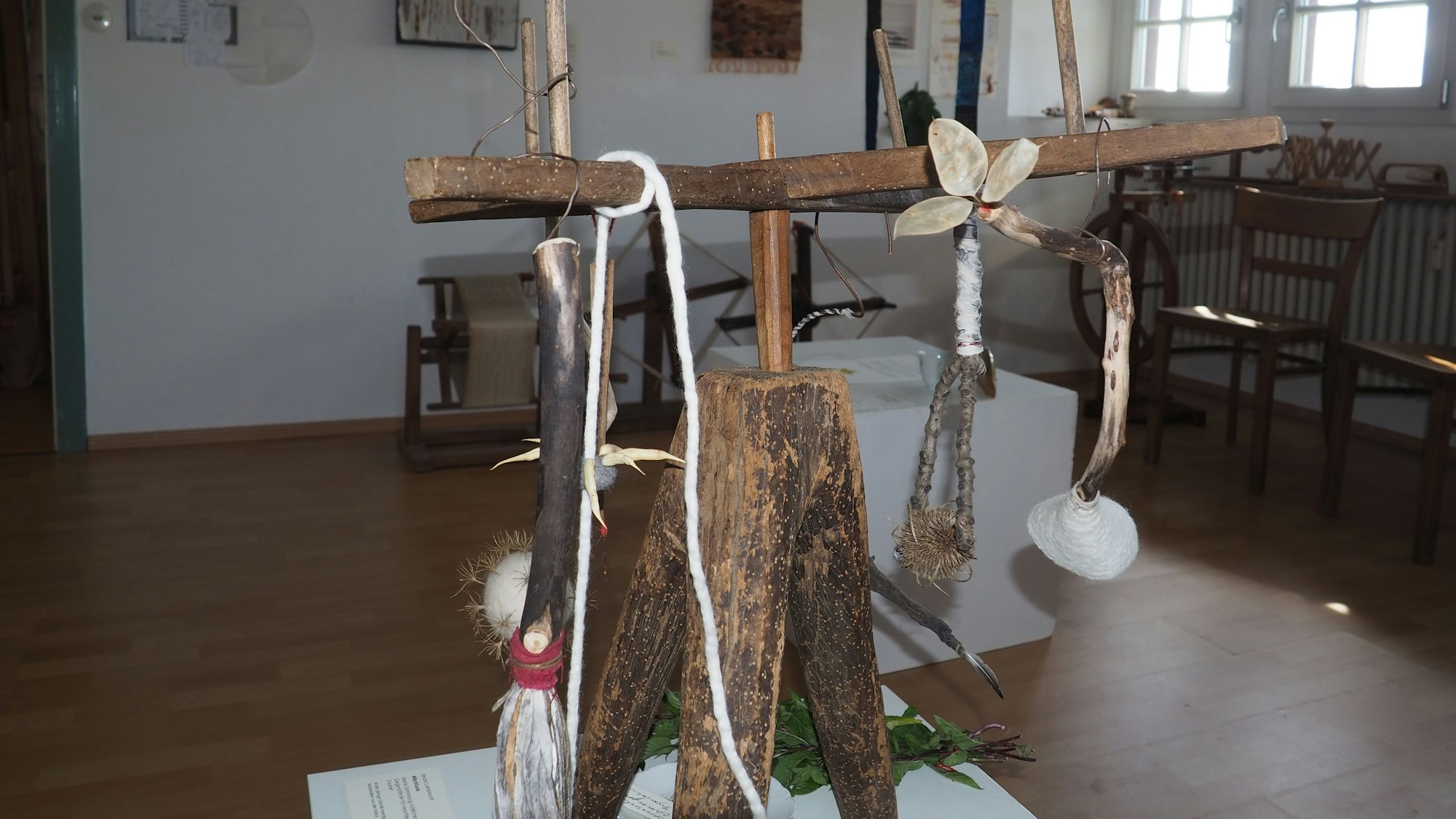 Das Bild zeigt einen Ausstellungsraum des Museums, im Vordergrund ein Objekt, das überwiegend aus Holz besteht.