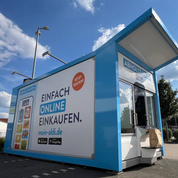Ein Abholautomat, bei dem die Nutzer vorher online bei Aldi Süd Lebensmittel bestellt haben, steht an einem Parkplatz vor einer Filiale des Discounters.