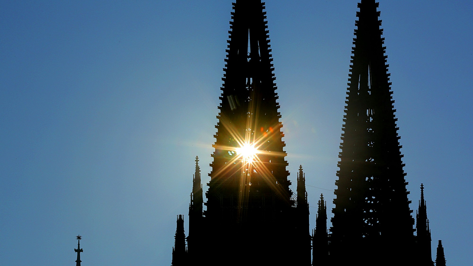 Sonnenstrahlen dringen durch den Nordturm am Kölner Dom. In Köln und der Region wird es am Sonntag und zu Wochenbeginn heiß. (Symbolbild)