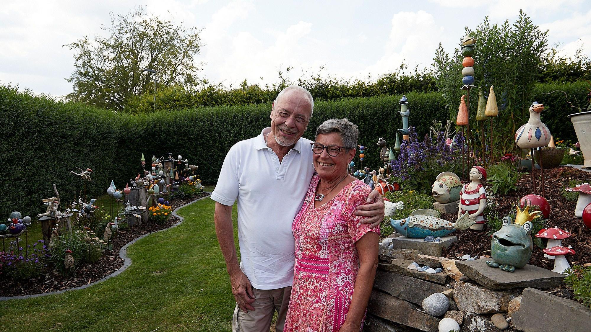 Klara und Rainer Martens stehen in ihrem Garten. Er hält den Arm um sie, beide lächeln.
