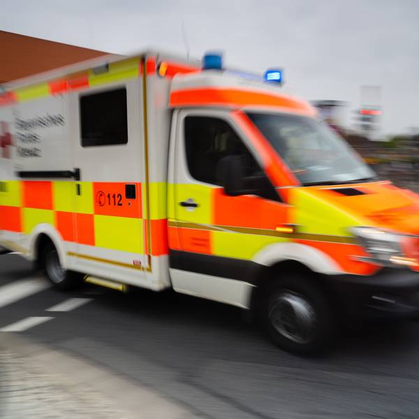 Es ist ein Krankenwagen zu sehen, der auf der Straße fährt.