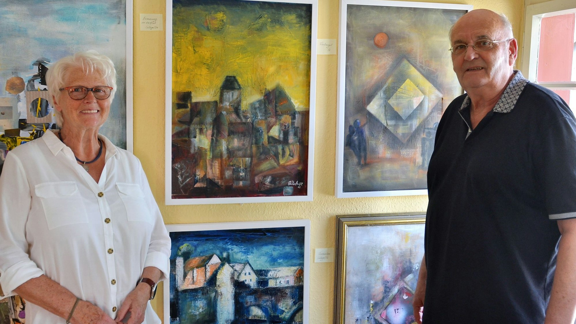 Katharina Münster und Fredy Kirchner stehen vor einigen ihrer Gemälde.
