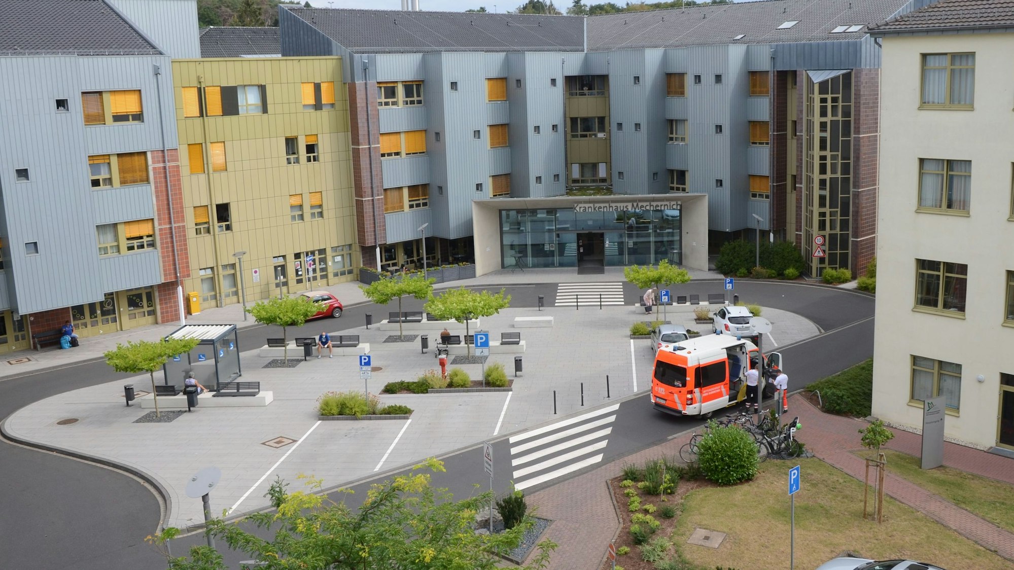 Außenansicht des Haupteingangs des Kreiskrankenhauses Mechernich. Ein Rettungswagen hält nahe der Einfahrt. Das Foto wurde aus erhöhter Perspektive aufgenommen.