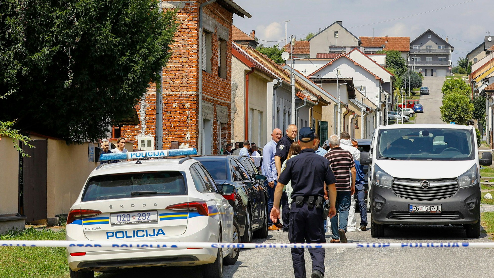 Polizei und Gerichtsmediziner stehen in der Nähe des Tatorts.