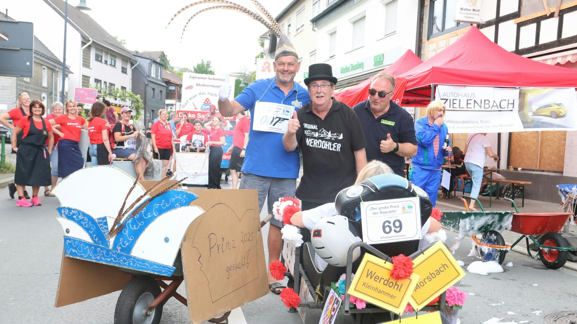 Während der frühere Karnevalsprinz Markus Held (links) um einen Nachfolger für die kommende Saison warb, freute sich Reinhard Kaldeich aus Werdohl (recht), dass er diesmal wirklich beim Schubkarrenrennen starten konnte. Auch ein Freund von Kaldeich (Mitte) drückte die Daumen.