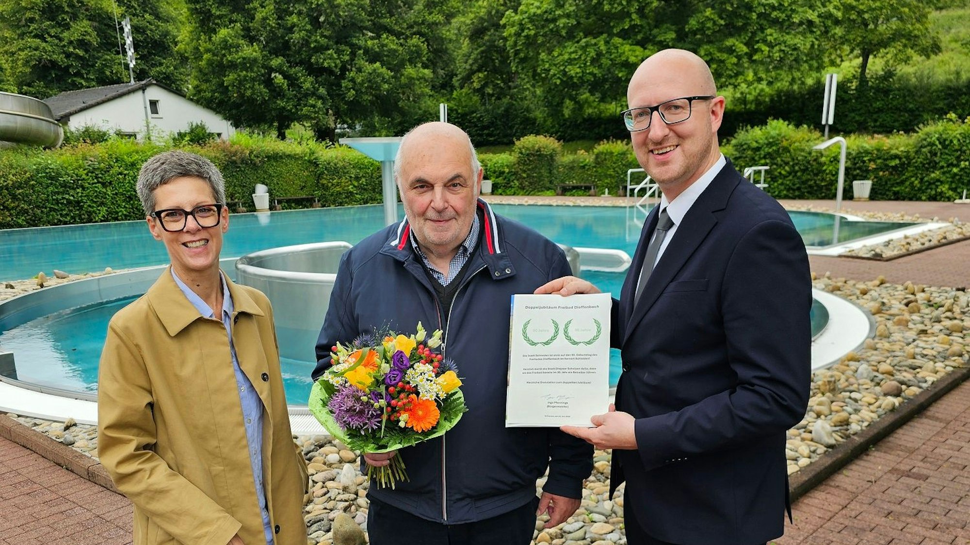 Bianka Renn (GfW) und Ingo Pfennings (r.) stehen neben Elmar Scholzen, der eine Urkunde in der Hand hält.