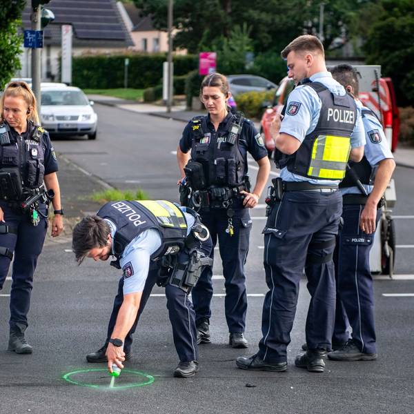 Das Bild zeigt Polizeibeamte an einer Unfallstelle, die Spuren sichern.