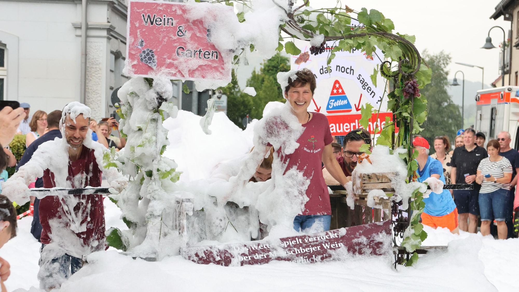 Die „Verkochten“ von der Gärtnerei Koch warben beim Morsbacher Schubkarrenrennen mit ihrem Vehikel und einem Stampfbottich für Wein aus der Gemeinde.