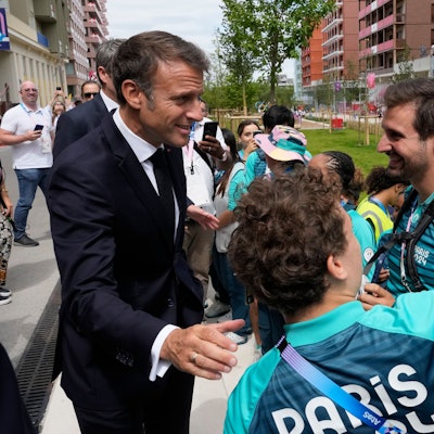 Frankreichs Präsident Emmanuel Macron posiert mit Volunteers für ein Foto.