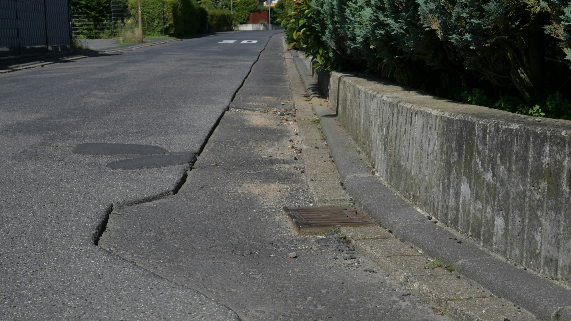 Die Asphaltdecke etlicher Straßen im Rösrather Ortsteil Kleineichen ist nach dem Verlegen von Glasfaser-Leitungen nur unzureichend wiederhergestellt. Durch die provisorische Abdeckung sind Schlaglöcher entstanden, Gullydeckel ragen zentimeterhoch hervor.