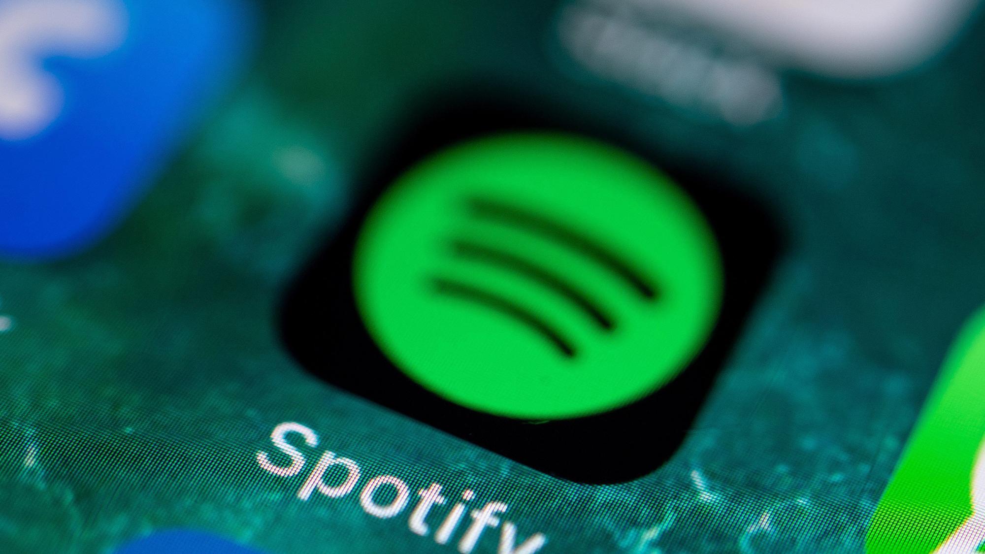 Die App des Musikdienstes Spotify wird auf dem Display eines iPhone angezeigt.