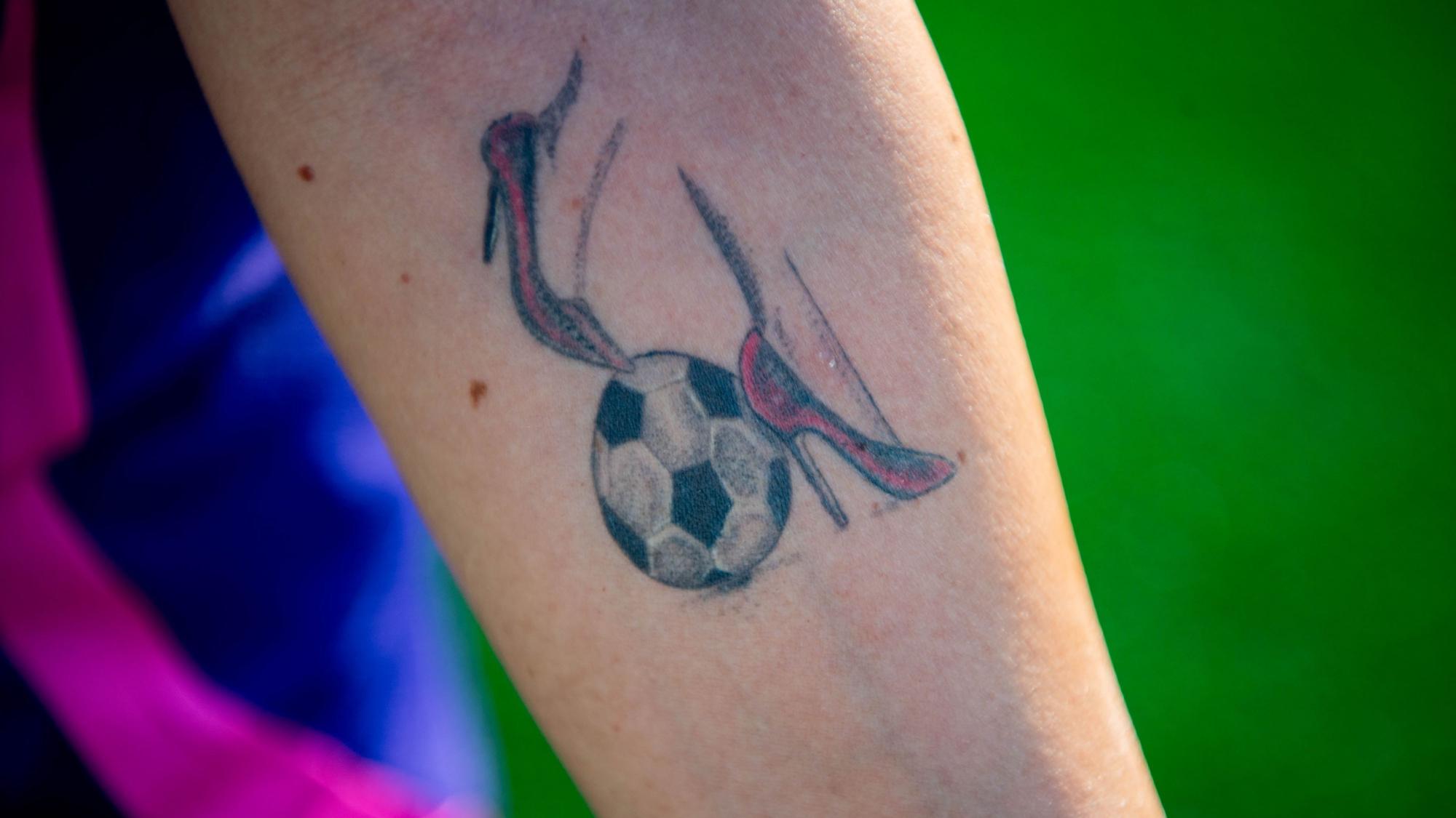 Das Bild zeigt das Tattoo von Marina Cardinale, die sich zwei rote High Heels und einen Fußball auf den Unterarm tätowiert hat.