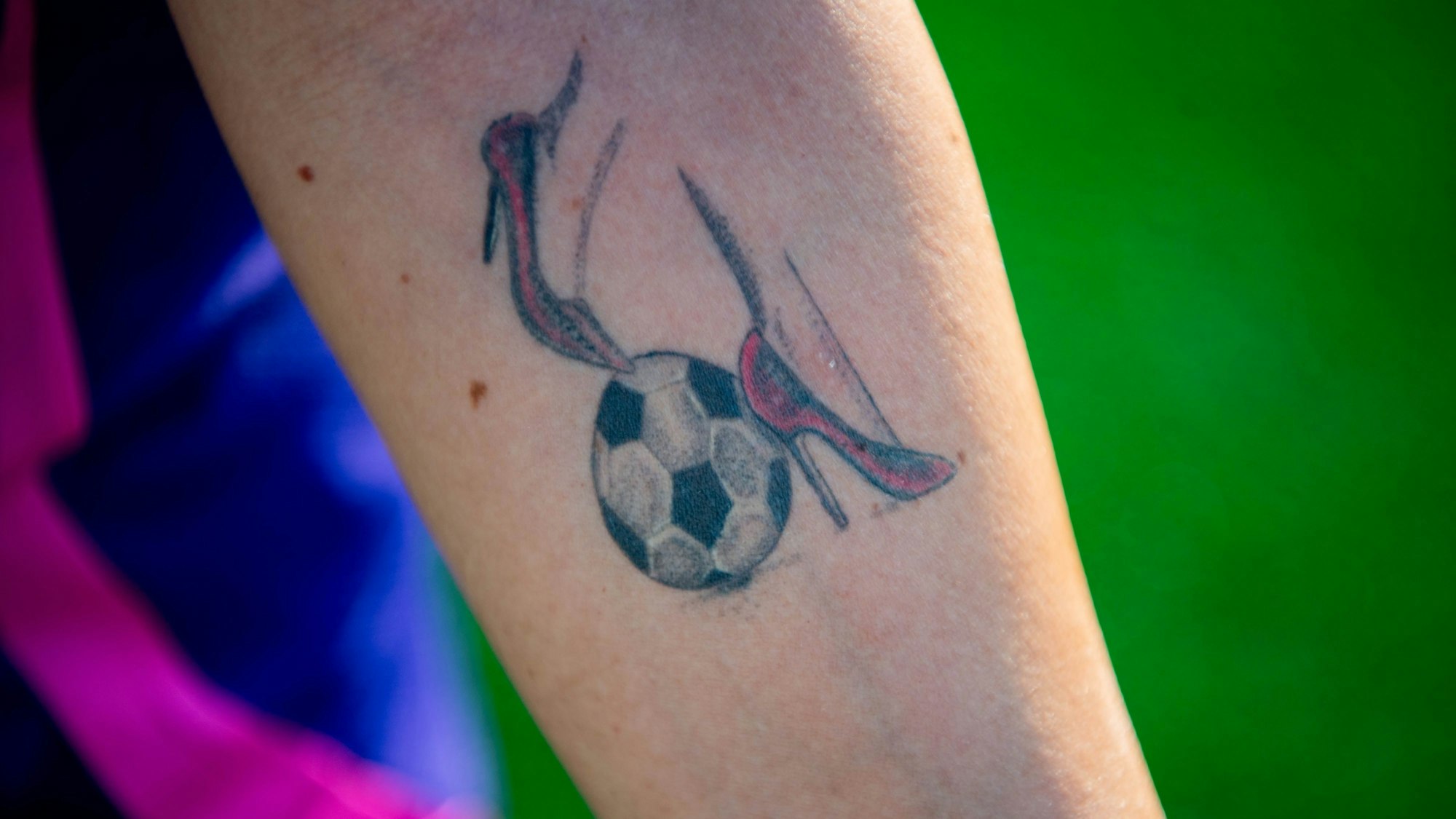 Das Bild zeigt das Tattoo von Marina Cardinale, die sich zwei rote High Heels und einen Fußball auf den Unterarm tätowiert hat.
