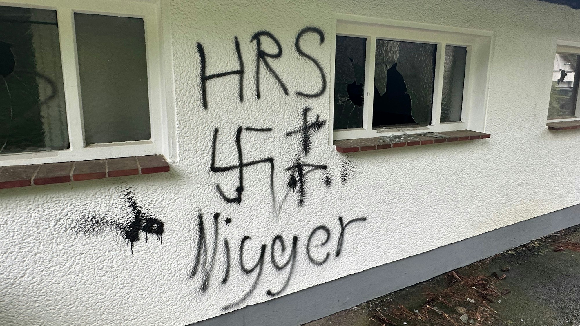 Schmierereien auf einer Hauswand: Das Wort „Nigger“ und ein Hakenkreuz.