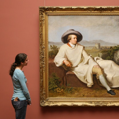 Eine Frau steht vor einem Bildnis von Goethe.