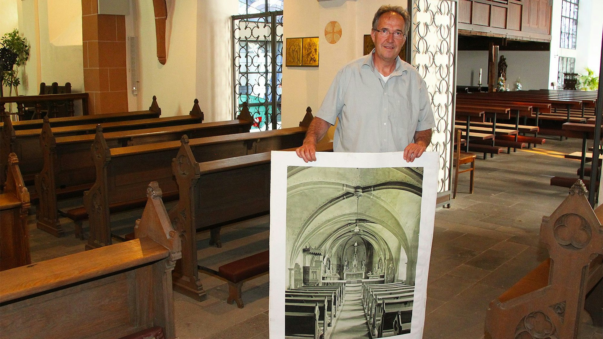 Gregor Mauel zeigt ein historisches Foto der Pfarrkirche St. Peter Zingsheim.