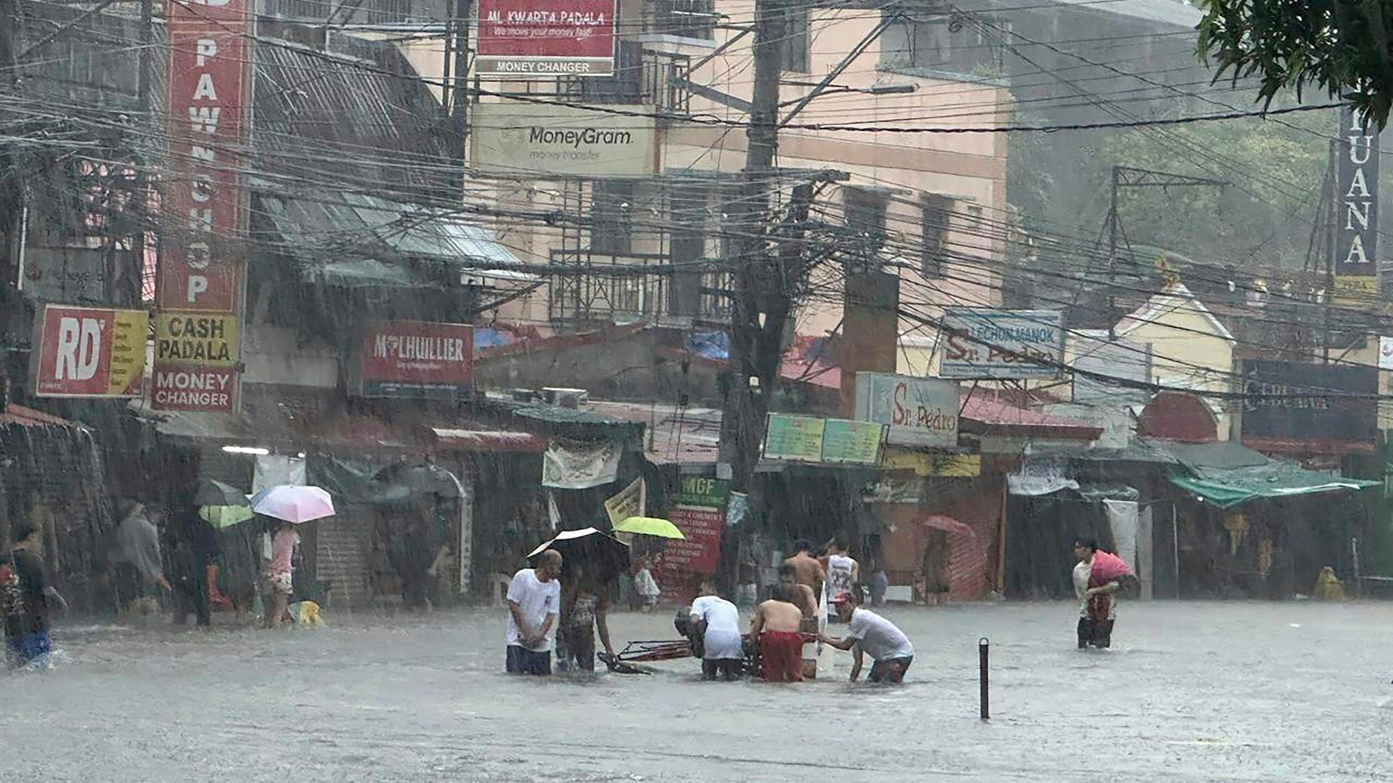 24.07.2024, Philippinen, Manila: Überschwemmte Straßen nach Monsunregen, der durch den Taifun Gaemi noch verstärkt wurde.