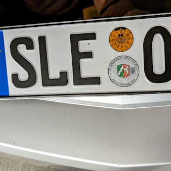 Ein Kennzeichen mit der Aufschrift „SLE“ liegt auf einem Auto.