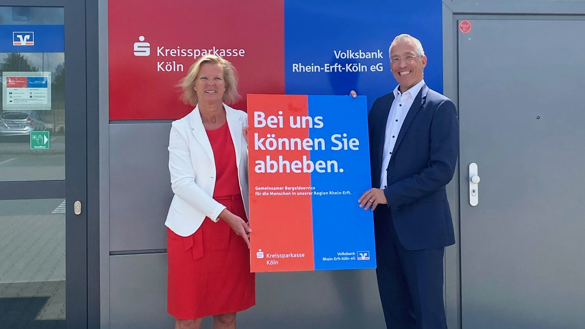 Ein Mann und eine Frau halten ein Plakat.