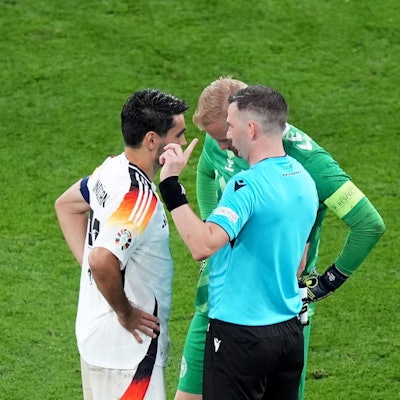 ARCHIV - 29.06.2024, Nordrhein-Westfalen, Dortmund: Fußball: EM, Deutschland - Dänemark, Finalrunde, Achtelfinale, Stadion Dortmund, Schiedsrichter Michael Oliver aus England spricht mit den beiden Kapitänen Ilkay Gündogan (l) und Dänemarks Kasper Schmeichel. (zu dpa: «Schiri-Chef fordert einheitliche Anwendung der Kapitänsregel») Foto: Marcus Brandt/dpa +++ dpa-Bildfunk +++