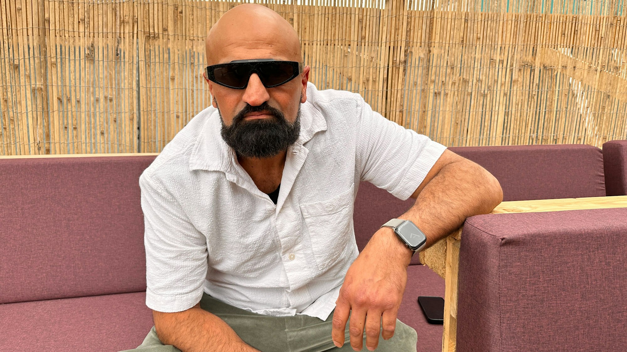 Rapper Xatar sitzt auf einer Außenlounge