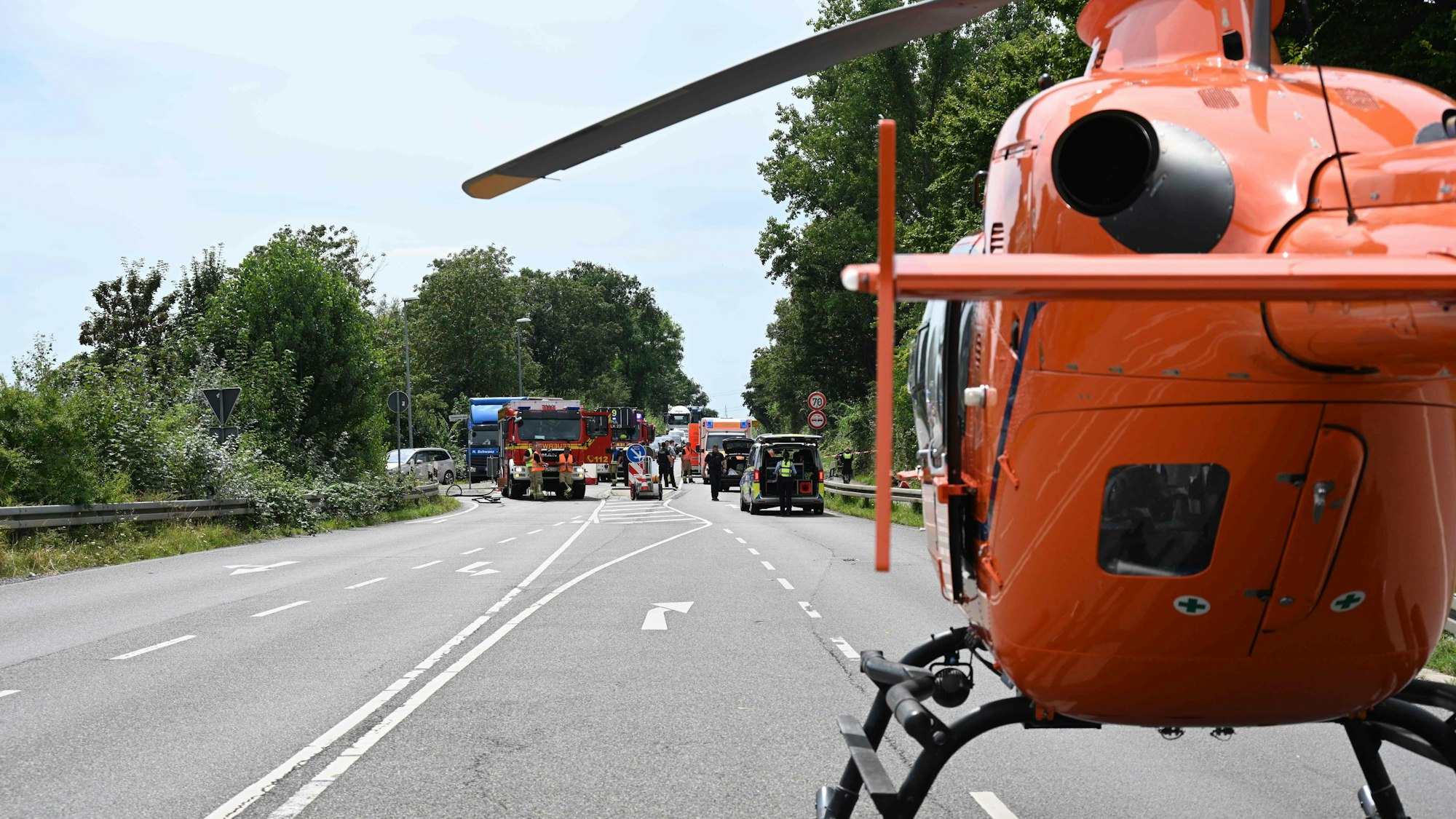 Ein Rettungshubschrauber ist auf der Straße gelandet, vor ihm ein Unfall.